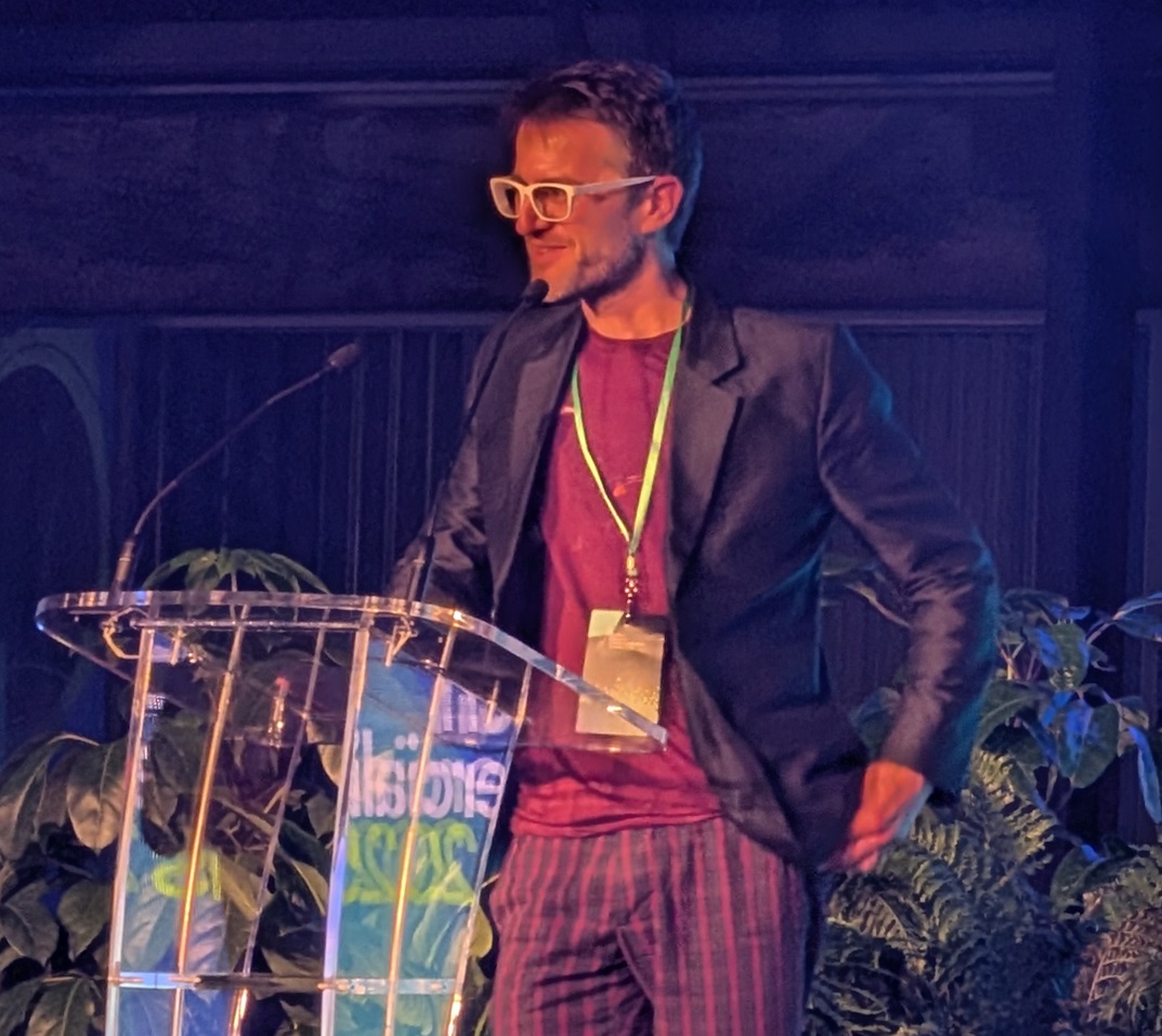 Photo of Dr Ben Mallett speaking at the podium.